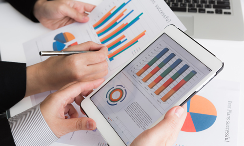 Close-up of business team using digital tablet with financial d